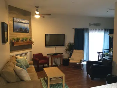 a living room with a couch and a flat screen tv at Heart of Peachland in Peachland