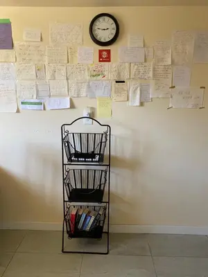 a shelf against a wall with a clock and papers at Richmond Vancouver Airport Comfy Home in Richmond