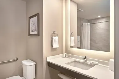 a bathroom with a sink and a toilet and a mirror at Fairfield Inn & Suites by Marriott Airdrie in Airdrie
