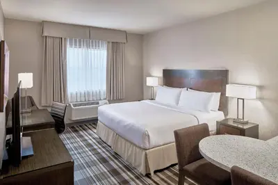 a hotel room with a large bed and a table at Fairfield Inn & Suites by Marriott Airdrie in Airdrie