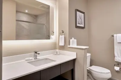 a white bathroom with a sink and a toilet at Fairfield Inn & Suites by Marriott Airdrie in Airdrie