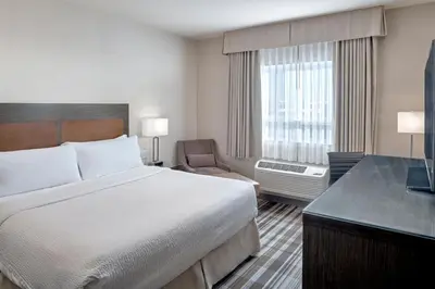 a hotel room with a bed and a chair and a window at Fairfield Inn & Suites by Marriott Airdrie in Airdrie