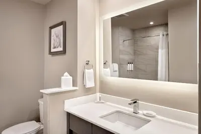 a bathroom with a sink and a toilet and a mirror at Fairfield Inn & Suites by Marriott Airdrie in Airdrie