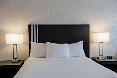 a bedroom with a large bed with two lamps at Park Inn by Radisson Edmonton Airport in Leduc