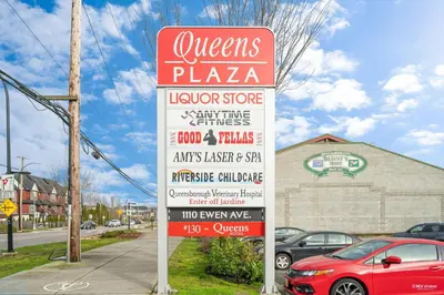 a sign for a pizza restaurant with a car parked in front at Queens Hotel in New Westminster