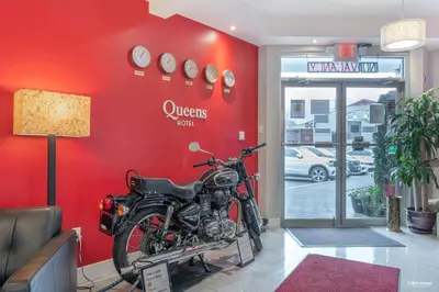 a motorcycle in a room with a red wall at Queens Hotel in New Westminster
