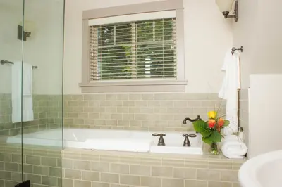 a bathroom with a bath tub with a window at The Cottages on Salt Spring Island in Ganges