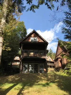 a large house with a balcony on the front of it at The Cottages on Salt Spring Island in Ganges