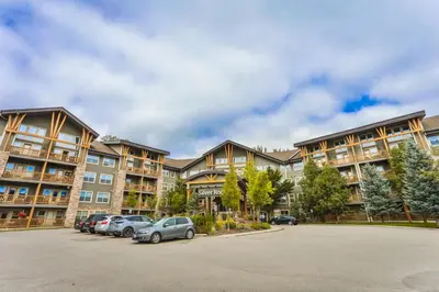 a large apartment building with cars parked in a parking lot at Silver Rock by StayIn in Fernie