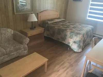 a bedroom with a bed and a couch and a chair at Green View Motel and RV Park in Greenwood