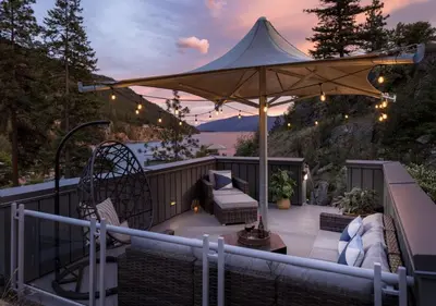 a patio with an umbrella and chairs and a table at Outback Lakeside Vacation Homes in Vernon