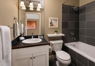 a bathroom with a toilet and a sink and a tub at Outback Lakeside Vacation Homes in Vernon
