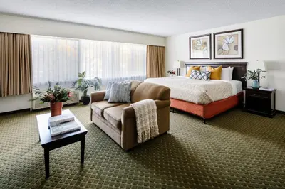 a hotel room with a bed and a couch at Chateau Jasper in Jasper