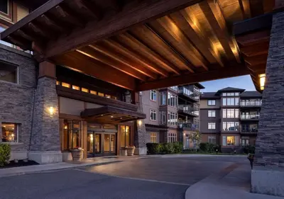 an exterior view of a building with a wooden pergola at The Cove Lakeside Resort in West Kelowna