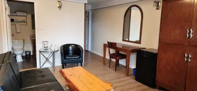 a living room with a table and a chair at Meares Vista Inn in Tofino