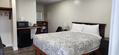 a bedroom with a bed with a white comforter at Meares Vista Inn in Tofino