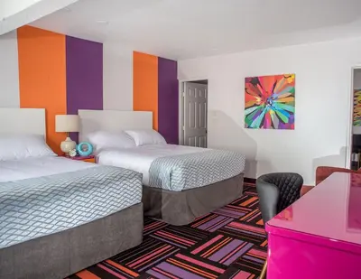 a hotel room with two beds and a colorful wall at Hotel Zed Kelowna in Kelowna
