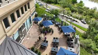 an overhead view of a restaurant with tables and blue umbrellas at Courtyard by Marriott Edmonton Downtown in Edmonton