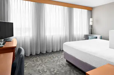 a hotel room with a bed and a television at Courtyard by Marriott Edmonton Downtown in Edmonton