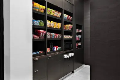 a walk in pantry with black cabinets and food at Courtyard by Marriott Edmonton Downtown in Edmonton