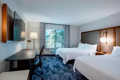 a hotel room with two beds and a desk and a window at Fairfield Inn & Suites by Marriott Kelowna in Kelowna