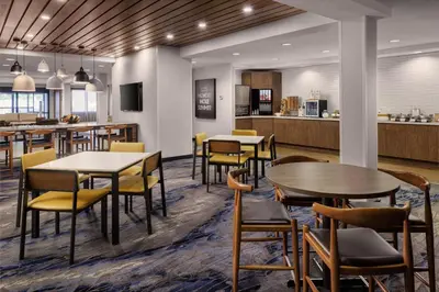 a restaurant with tables and chairs and a kitchen at Fairfield Inn & Suites by Marriott Kelowna in Kelowna