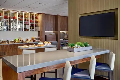 a dining room with a table and chairs and a flat screen tv at Calgary Marriott Downtown Hotel in Calgary