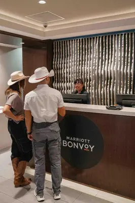 a man and woman standing at a marriott banbury counter at Calgary Marriott Downtown Hotel in Calgary