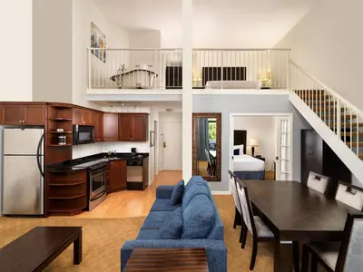 a kitchen and living room with a table and a dining room at Huntingdon Hotel and Suites in Victoria