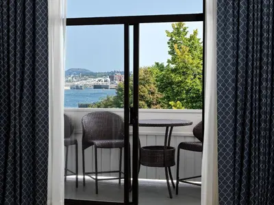 a balcony with a table and chairs and a view of the water at Huntingdon Hotel and Suites in Victoria