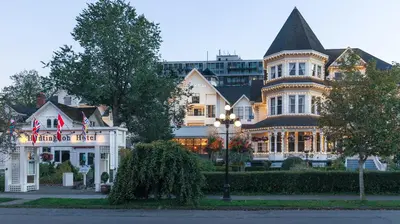a large white house with a turret at Huntingdon Hotel and Suites in Victoria