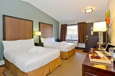 a hotel room with two beds and a desk at Centro Motel in Calgary
