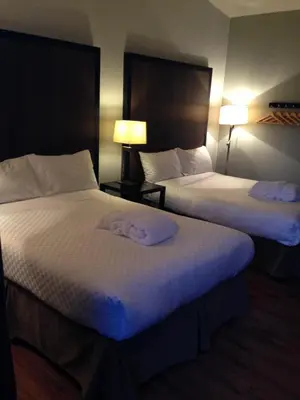 two beds in a hotel room with towels on them at Centro Motel in Calgary