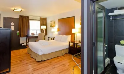 a hotel room with a bed and a bathroom at Centro Motel in Calgary
