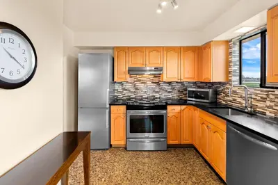 a kitchen with wooden cabinets and a clock on the wall at Best Western PLUS Inner Harbour Hotel in Victoria
