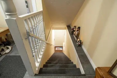 a group of people walking down a staircase at Vacation Homes by The Bulldog- Berker's Suite A in Silver Star