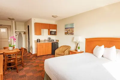 a hotel room with a bed and a kitchen at Service Plus Inns and Suites Calgary in Calgary