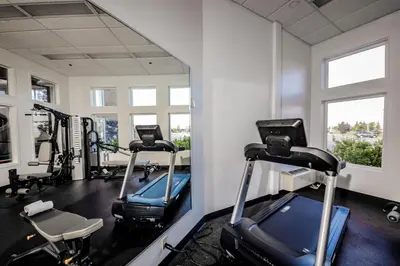 a gym with tread machines and a mirror at Service Plus Inns and Suites Calgary in Calgary