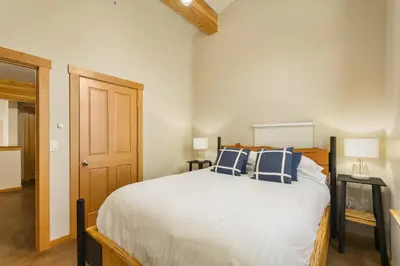 a bedroom with a bed with blue and white pillows at The Mountain Project #2 in Rossland