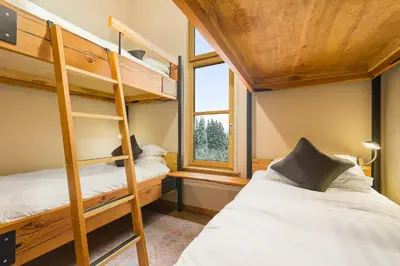 two bunk beds in a small room with a window at The Mountain Project #2 in Rossland