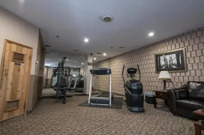 a living room with a room with a television and a couch at Argyll Plaza Hotel in Edmonton