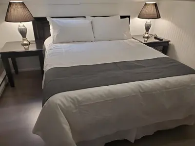 a bedroom with a large bed with two lamps on tables at Celadon Lodge in Radium Hot Springs