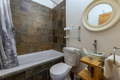 a bathroom with a tub and a toilet and a sink at Canyon Ridge Lodge in Golden