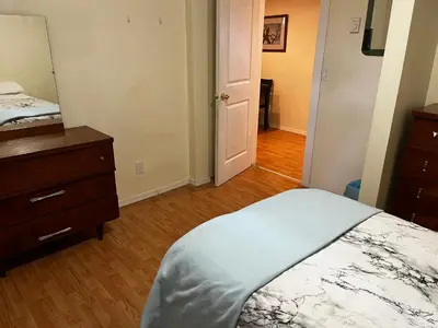 a bedroom with a bed and a dresser and a mirror at Revelstoke Long Term in Revelstoke