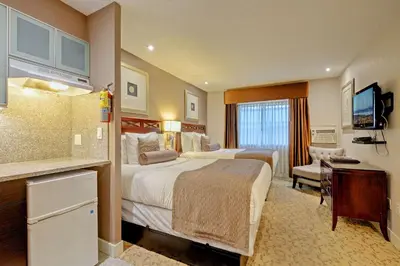 a hotel room with two beds and a television at Red Lion Inn and Suites Victoria in Victoria