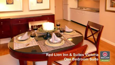a dining room table with a candle and wine glasses at Red Lion Inn and Suites Victoria in Victoria