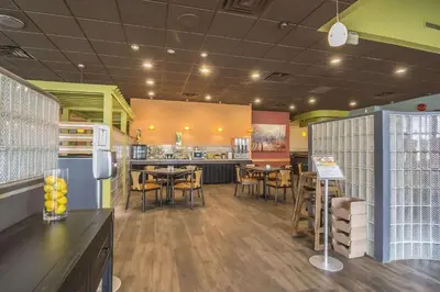 a restaurant with tables and chairs and a kitchen at Quality Inn West Edmonton in Edmonton