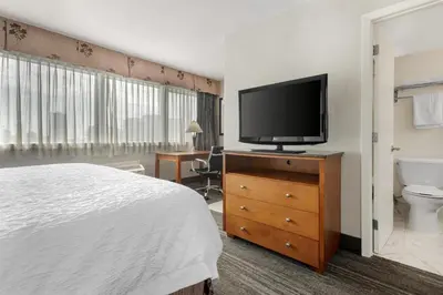 a bedroom with a bed and a television on a dresser at Best Western Plus Suites Downtown Calgary in Calgary