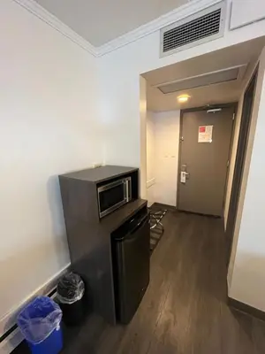 a room with a microwave and a hallway with a door at Super 8 by Wyndham Macleod Trail Calgary in Calgary