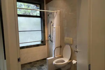 a bathroom with a toilet and a window and a shower at The Perch at Moon Dance in Garden Bay